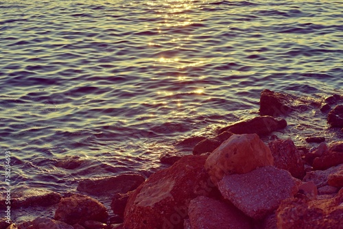 Calm sea and rocks with sun reflection