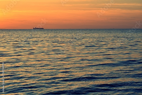 Ship sailing over the horizon during sunset