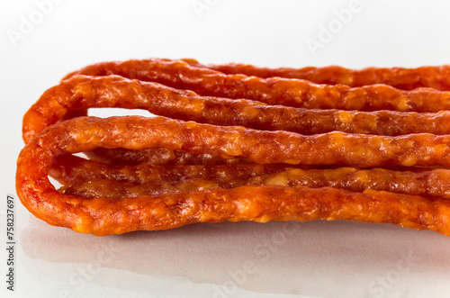 Many thin sausages on a white background