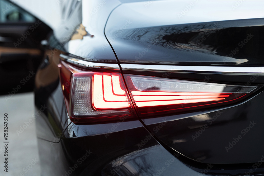 Close up detail on one of the LED red taillight modern luxury car. Car back lights shining. Exterior detail automobile. Tail light car. Detail on the rear light of a car