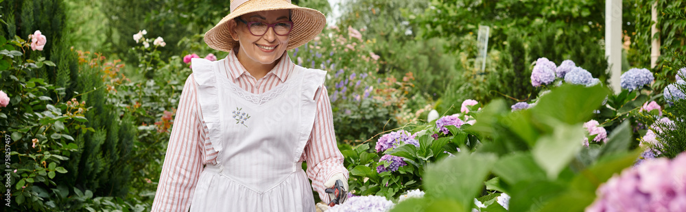 jolly mature woman with apron and gardening tools taking care of beautiful hydrangea, banner