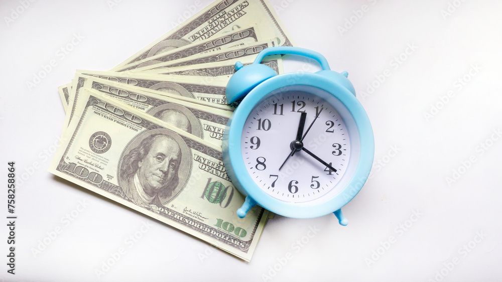 Time - money concept with clock and dollar bills closeup on white background Time - money concept with clock and dollar bills closeup on white background