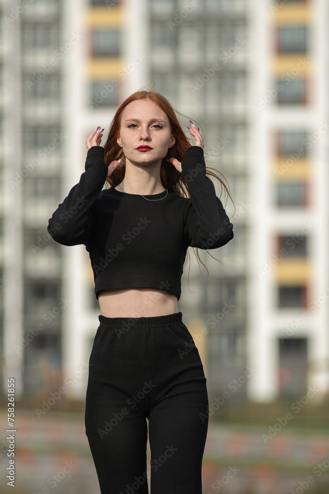 Obraz premium Portrait of a young beautiful red-haired girl outdoors.