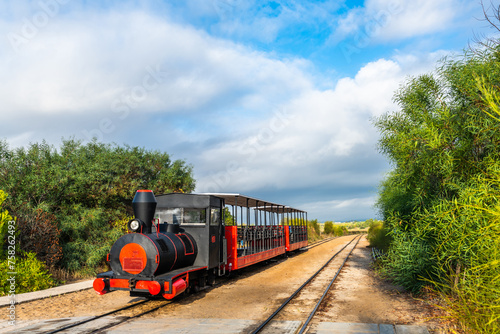 Retro train that transports visitors from the mainland to the Barril beach near Tavira, Portugal. photo