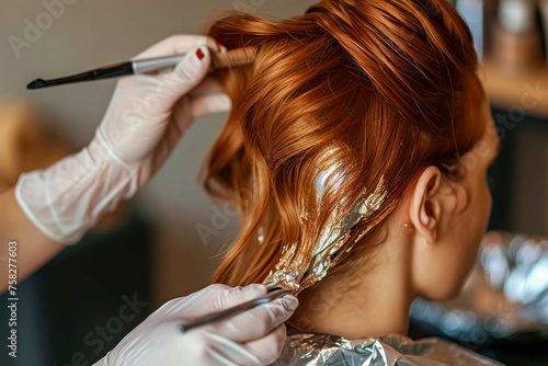 model coloring their hair with a dye and a bowl in the background and a glove and a foil on their hair