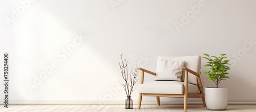 A cozy living room with a wooden chair and a lush plant placed on a table in front of a white wall. The room is filled with art and has hardwood flooring