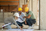 A group of architects work together on-site, discussing blueprints and coordinating to bring their project to life. 