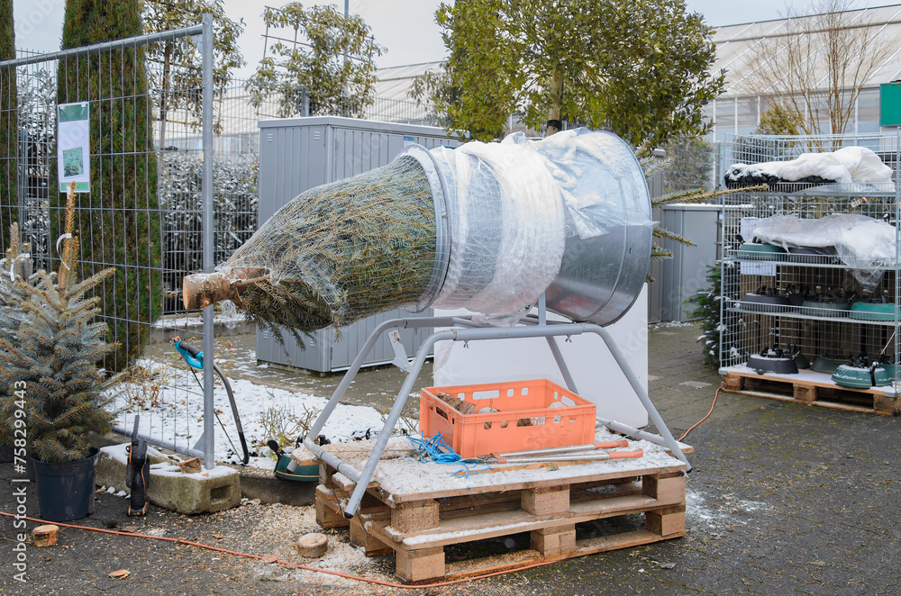 Naklejka premium Christmas tree wrapping machine with a tree.
