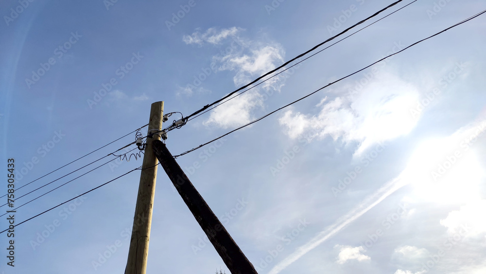 Fototapeta premium Old pole with wires against the sky. Electric transmission line. Eco-friendly energy