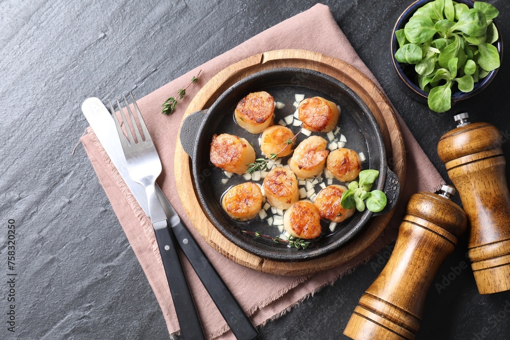 Delicious fried scallops in dish served on dark gray textured table, flat lay Delicious fried scallops in dish served on dark gray textured table, flat lay