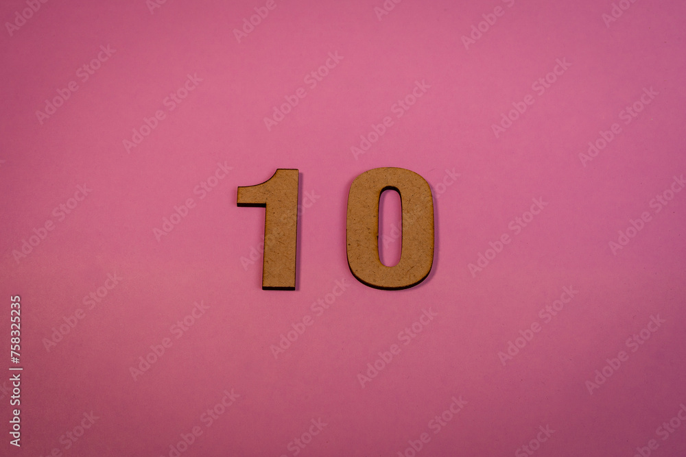 Number 10 in wood on a pink background Number 10 in wood on a pink background