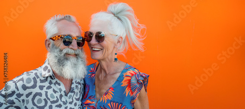 Caucasian modern cool couple wearing colorful outfit and sunglasses over orange background with copy space