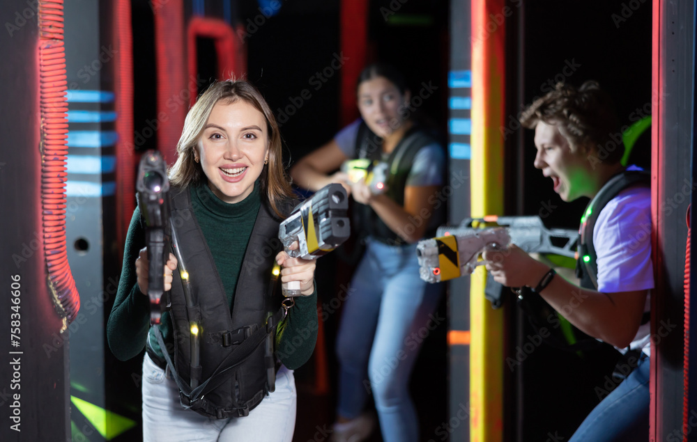 Young lady having fun playing lasertag in arena