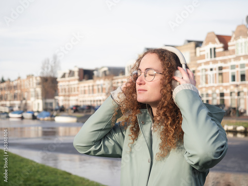 Canvas Print Relaxed Young Woman Enjoying Music by the Riverside