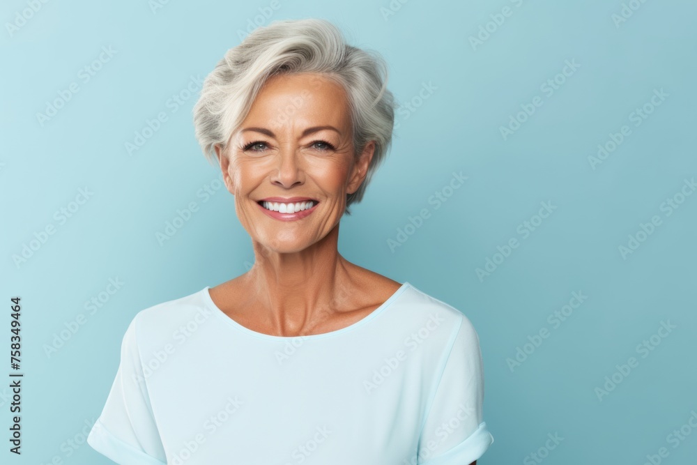 Portrait of smiling senior woman on blue background with copy space. Portrait of smiling senior woman on blue background with copy space.