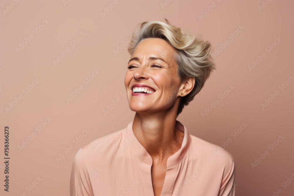 Happy senior woman with short hair smiling. Portrait of a beautiful mature woman on a pink background. Happy senior woman with short hair smiling. Portrait of a beautiful mature woman on a pink background.