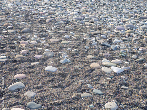 Gray sand and stones on the beach. Beach in winter.  Dry sand with traces