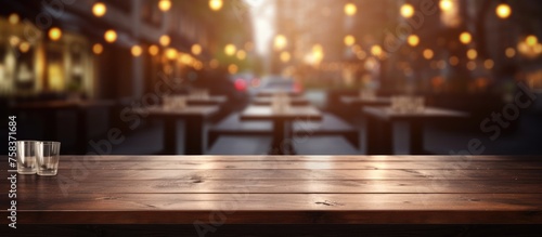 Empty dark wooden table set against blurred restaurant background, suitable for showcasing products. © Vusal