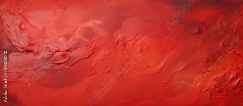A closeup shot showcasing a red background with a marble texture, featuring hints of peach, magenta, and carmine colors. The pattern resembles swirling cumulus clouds on a stormy day