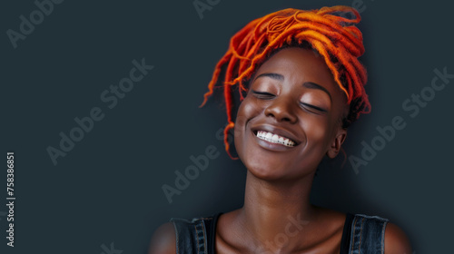 Porträt einer jungen schwarzen Frau mit zufriedenem Lächeln und leuchtend orangefarbenen Dreadlocks.