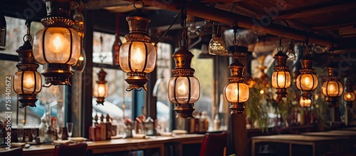 An array of lanterns, made of metal and wood, hang from the ceiling of the restaurant, creating a warm and cozy ambiance in the room