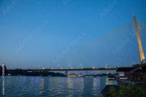 Panorama of the Belgrade bridge over the Sava river (Ada most) taken during a summer night with roads in front of rafts called splav. Beograd is the capital city of Serbia.