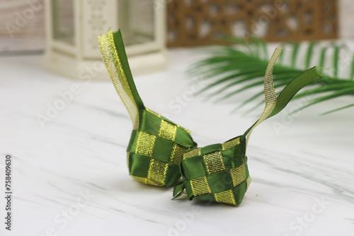 Ketupat lebaran made from green and gold ribbon. Ramadan and Hari Raya decoration for template, card and background.