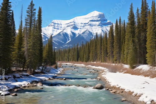 Scenic Mountain River Flowing Through Lush Valley with Snow-Covered Banks and Evergreen Trees in Banff National Park, Canada, Perfect for Nature Lovers and Adventure Seekers