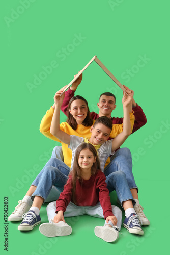 Little children with their parents and cardboard paper on green background © Pixel-Shot