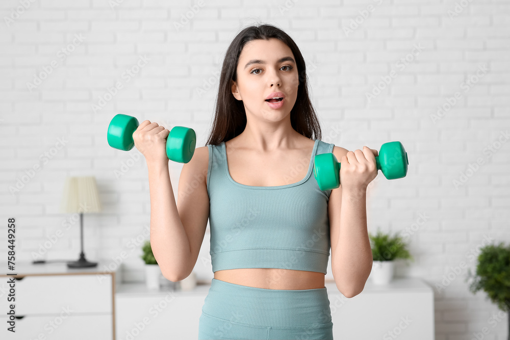 Female sports blogger with dumbbells recording video at home Female sports blogger with dumbbells recording video at home