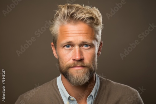 Portrait of a handsome man with blond hair and beard on a brown background