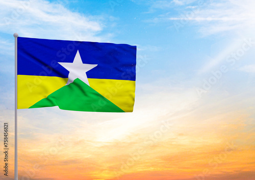 3D illustration of a Rondonia flag extended on a flagpole and in the background a beautiful sky with a sunset