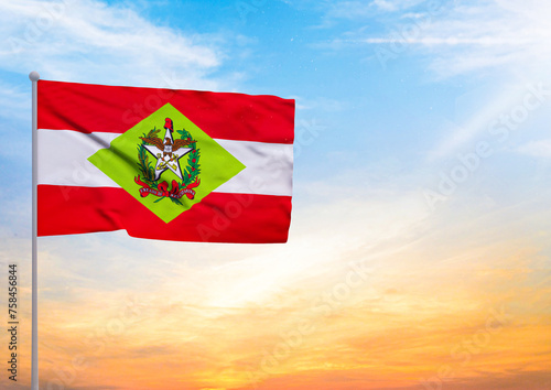 3D illustration of a Santa Catarina flag extended on a flagpole and in the background a beautiful sky with a sunset