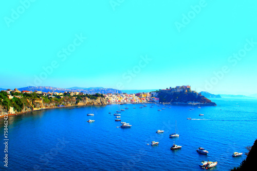 Enchanting vista from Isola di Procida in the Gulf of Naples at the vivid pastel buildings of Marina di Corricella, breakwaters, boats, Terra Murata, Palazzo d'Avalos, Punta dei Monaci, Tyrrhenian Sea photo