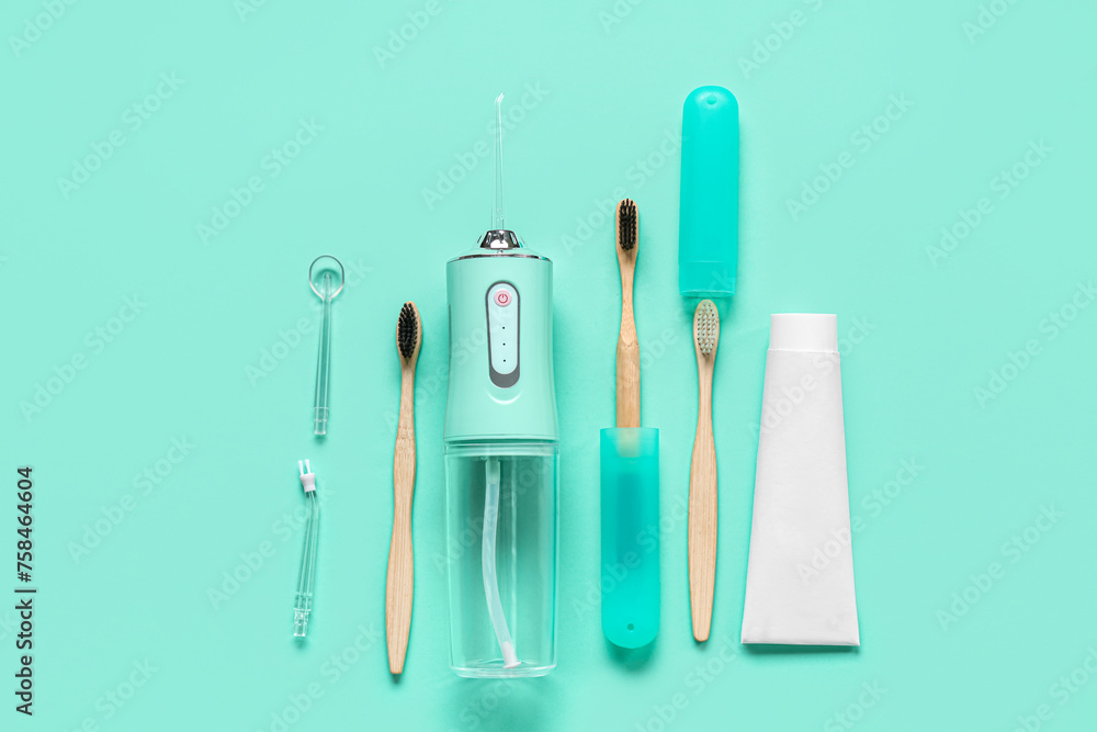 Set for dental hygiene with oral irrigator on turquoise background Set for dental hygiene with oral irrigator on turquoise background