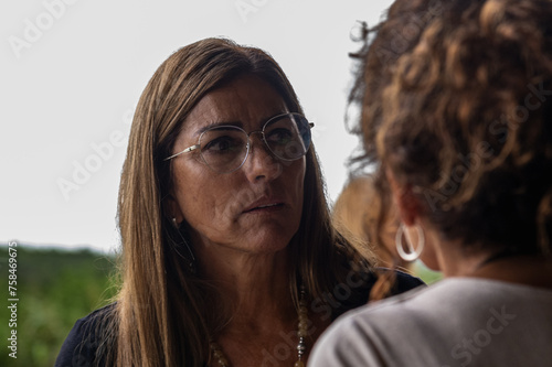 adult woman with glasses talking seriously to another
