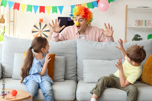 Slika na platnu Father in colorful clown wig surprising his children at home