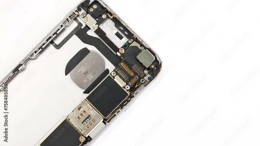 Open smartphone under maintenance on a white surface, revealing its internal complexity. Close view of a disassembled phone for maintenance on a white base, exposing its inner structure. Open smartphone under maintenance on a white surface, revealing its internal complexity. Close view of a disassembled phone for maintenance on a white base, exposing its inner structure.