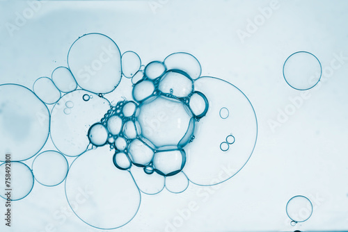 Gel droplets with diffrent sized bubbles pattern, lap dropltes on blue background.  Ideal for face care, test skin. photo