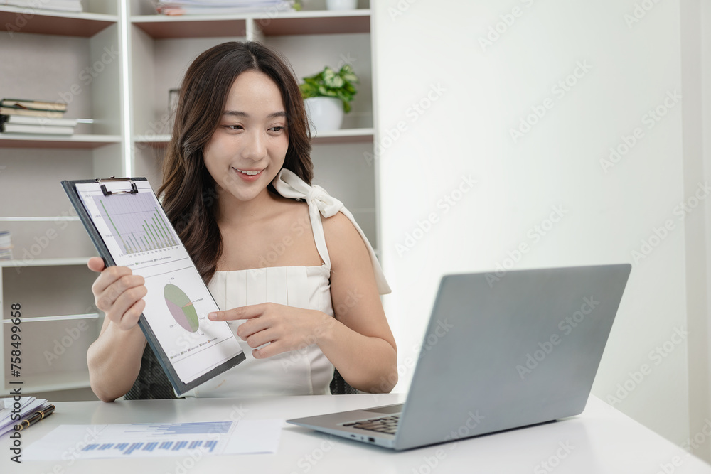 Asian female accountant working on laptop and doing paperwork, tax, trading, and financial consulting and accounting analysis investment information report Financial concepts and tax system Asian female accountant working on laptop and doing paperwork, tax, trading, and financial consulting and accounting analysis investment information report Financial concepts and tax system