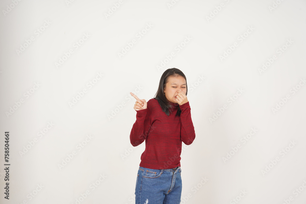 Young Asian woman in Red t-shirt Smelling something stinky and disgusting isolated on white background Young Asian woman in Red t-shirt Smelling something stinky and disgusting isolated on white background