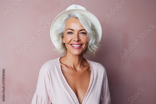 Portrait of a beautiful senior woman with hat smiling at the camera
