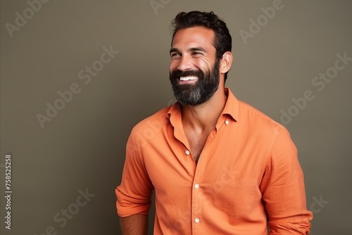 Portrait of a handsome young man in orange shirt smiling at the camera