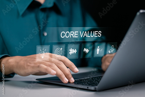 Core values responsibility ethics goals company concept. Businessman using laptop with Core Values icons on virtual screen.