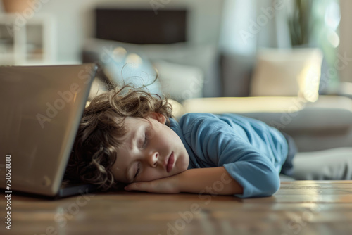 A tired kid hugging laptop and sleeping on the table
