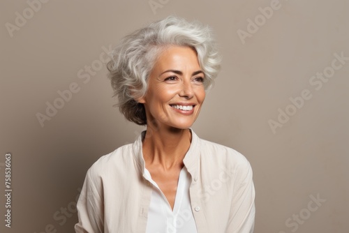 Portrait of happy senior woman with grey hair and white shirt.