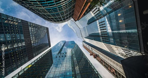 4K Footage Time lapse Low angle of tall corporate buildings skyscraper with reflection of clouds among high buildings and glass elevator in building center in London, England, United Kingdom photo