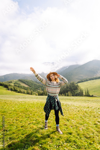 Woman tourist in a hat backpack travel mountains relaxation. Traveler enjoying nature. Adventures.