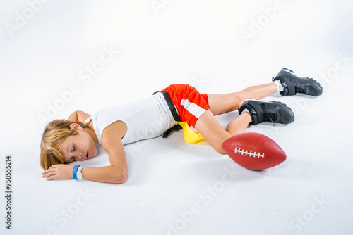 Young male flag football player lying injured on the ground unconscious