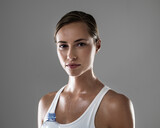 Woman, portrait and fitness with sweat or water bottle for hydration after workout on a gray studio background. Face of female person or athlete with liquid or drink for exercise, health or wellness